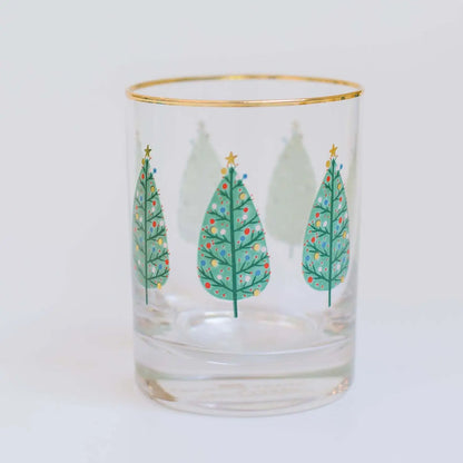 Short drinking glass with gold rim and Christmas trees painted around the glass.